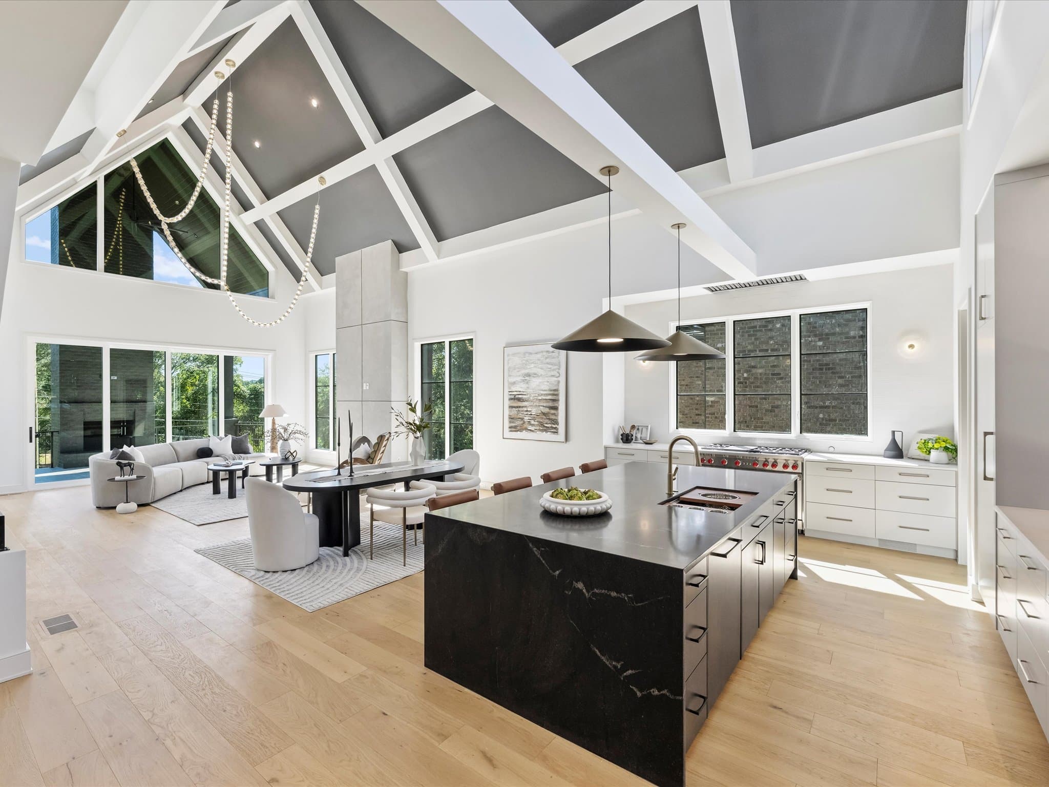 Lorna cathedral great room — exposed beams, black stone waterfall island, custom home by Royal Building Group